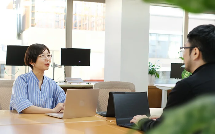 写真　社員三名が談笑しながら相談している様子